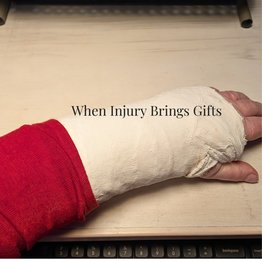 A hand with a white cast rests on a wooden surface. A red sleeve is visible. Text reads: "When Injury Brings Gifts." Keyboard below.