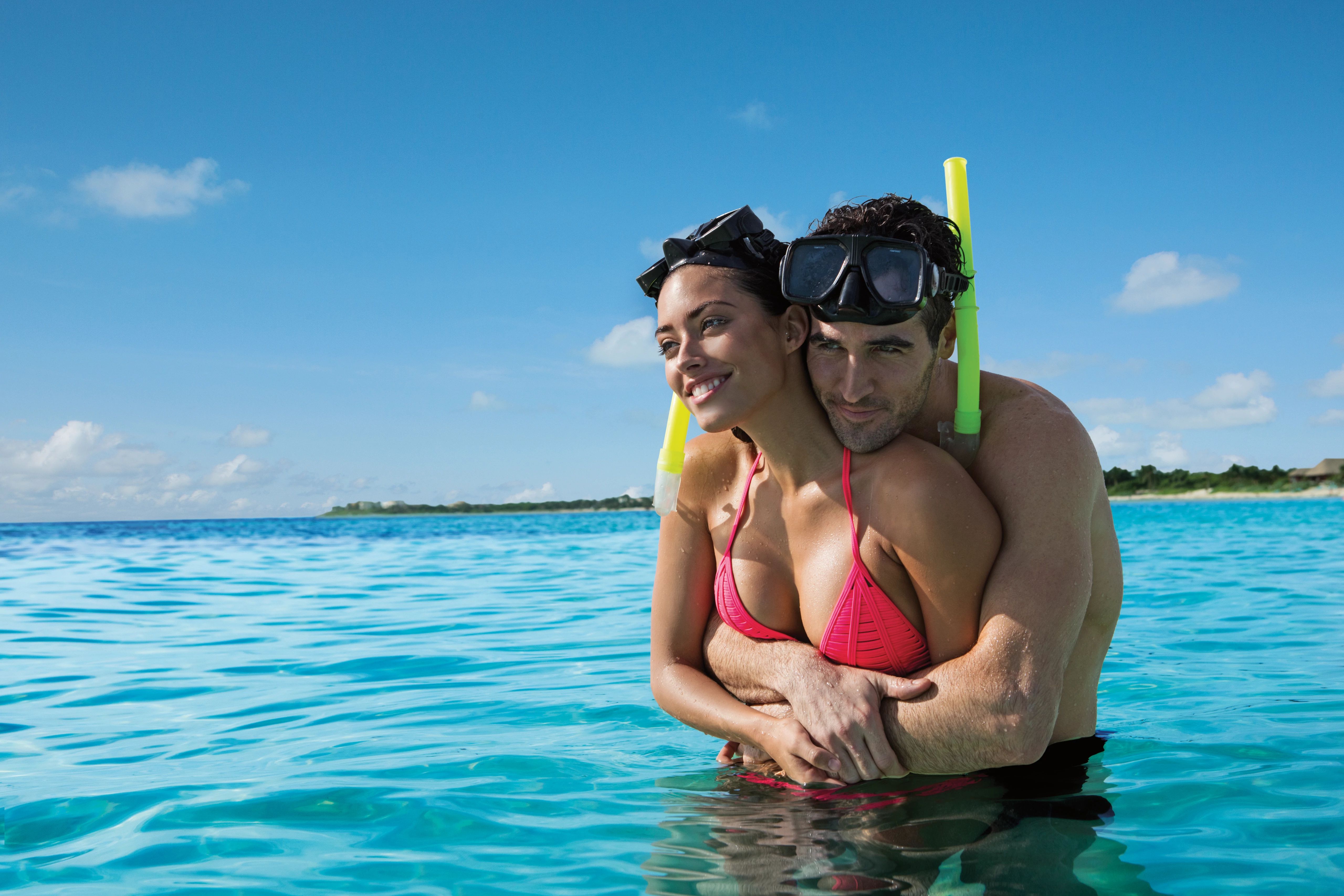 couple embracing in the ocean in snorkeling gear