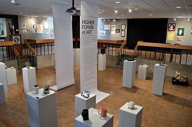 Interior view of Higher Forms of Art exhibition in the Danforth Gallery at UMA showing exhibition banners and works on pedestals