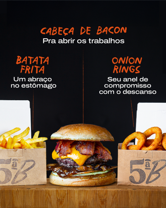 Na imagem temos o hambúrguer chamado Cabeça de Bacon da hamburgueria Quinta B. De um lado, temos uma porção de fritas e do outro, uma porção de onion rings.
