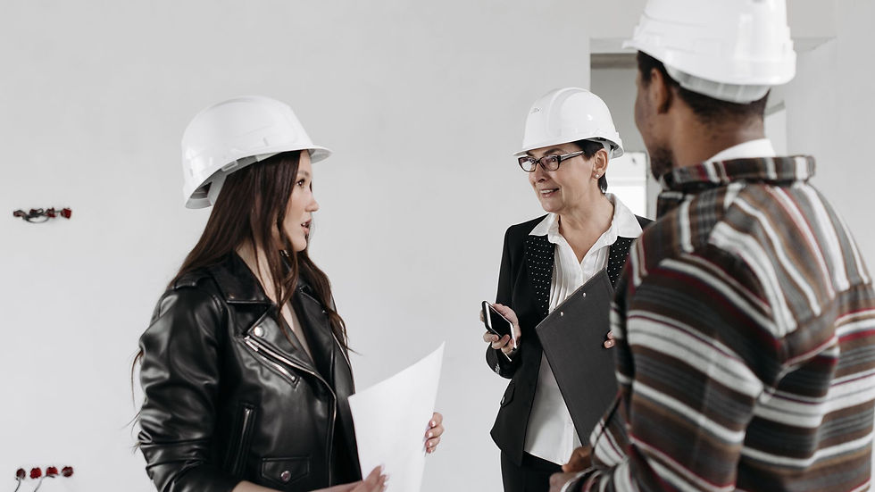 Professional team of architects in hard hats discussing project plans inside a building.