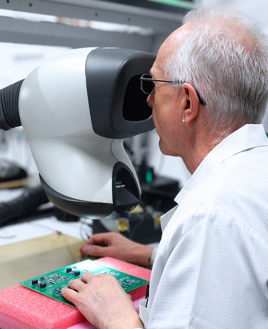 Techniker prüft Leiterplatte an optischem Inspektionsgerät