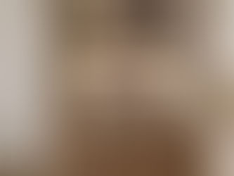 “Modern cozy minimalist living room with warm earth tones, textured wall panelling, oak furniture, layered lighting and neutral boucle sofa designed by Jorna Living interior design studio in the UK.”