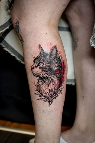 Tattoo de tête de chat sur un mollet. Tatouage féminin
