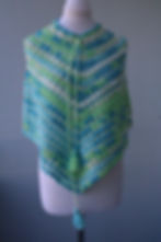 Drift & Dream Poncho for kids – handmade crochet poncho in soft blue, green and white yarn with tassel ties displayed on mann