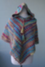 Handmade Rainbow Spell crochet hooded poncho for kids with rainbow yarn and tassel ties.