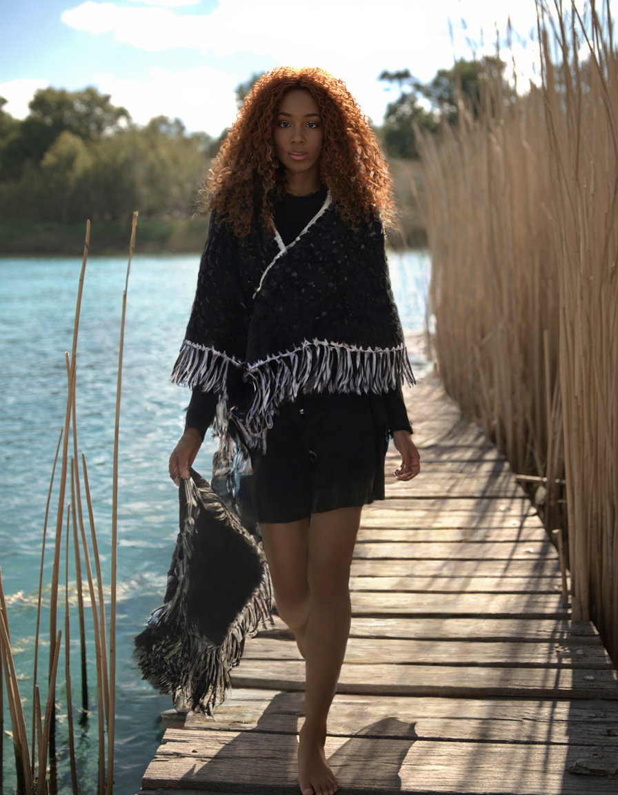 Midnight Lagoon black wool crochet poncho worn beside the water
