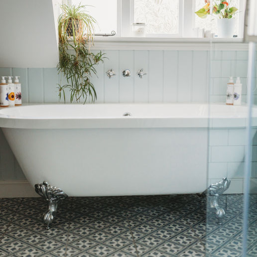Freestanding bath beside a large window in the main bathroom at The Coach House