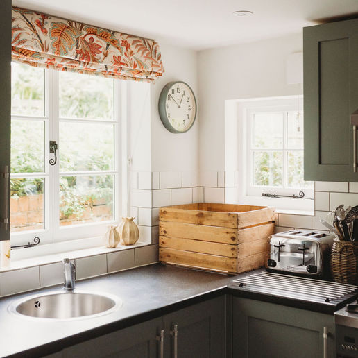 Green fitted kitchen with a garden-facing window at Manor House Lodge