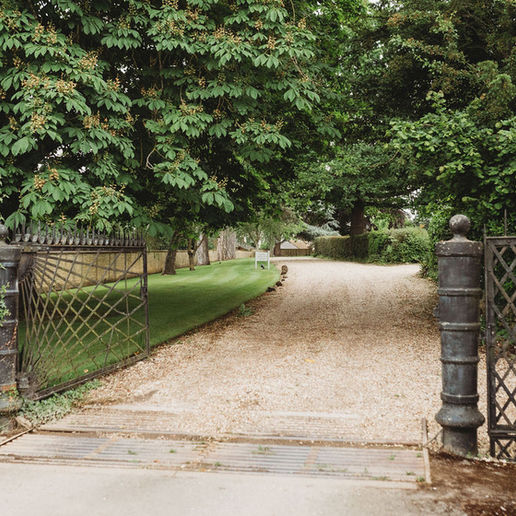 Open metal gates beside Manor House Lodge on Main Road in Bredon