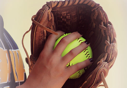 Close-up of softball glove and ball used in personalized internal-rotation pitching training at Conviction Fastpitch