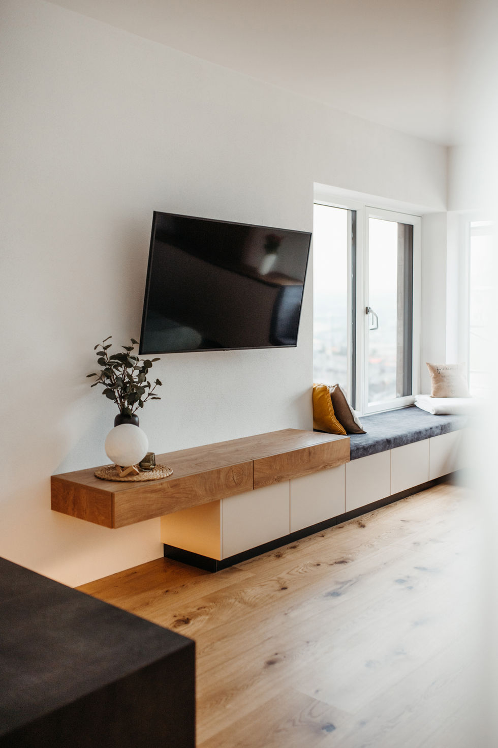 Wohnzimmer mit großem, gemütlichen Daybed über die Ecke und schönem Schrankverbau mit Holzpaneelen