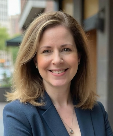 Headshot of Michelle V. Peña wearing a blue suit and taken outdoors.