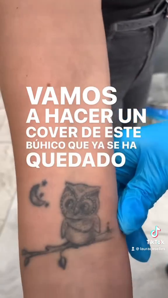 Tatuaje anterior de un búho oscuro sobre una rama, con una luna a su lado, en el antebrazo