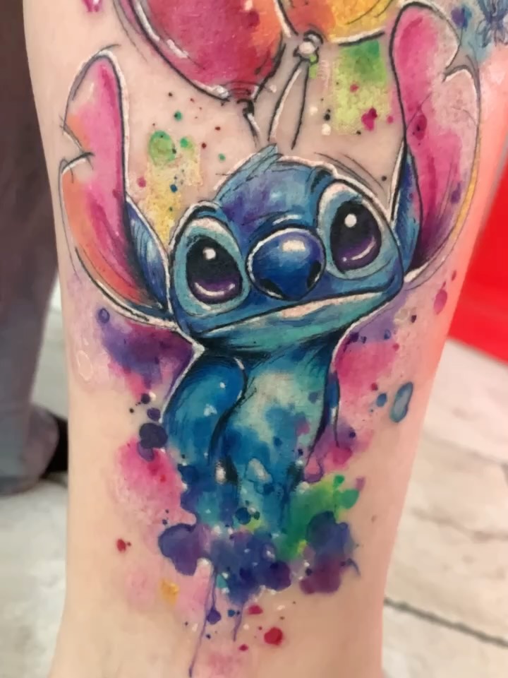 Close-up of the Stitch cover-up: dark eyes and blues beside pink, purple and green watercolour areas