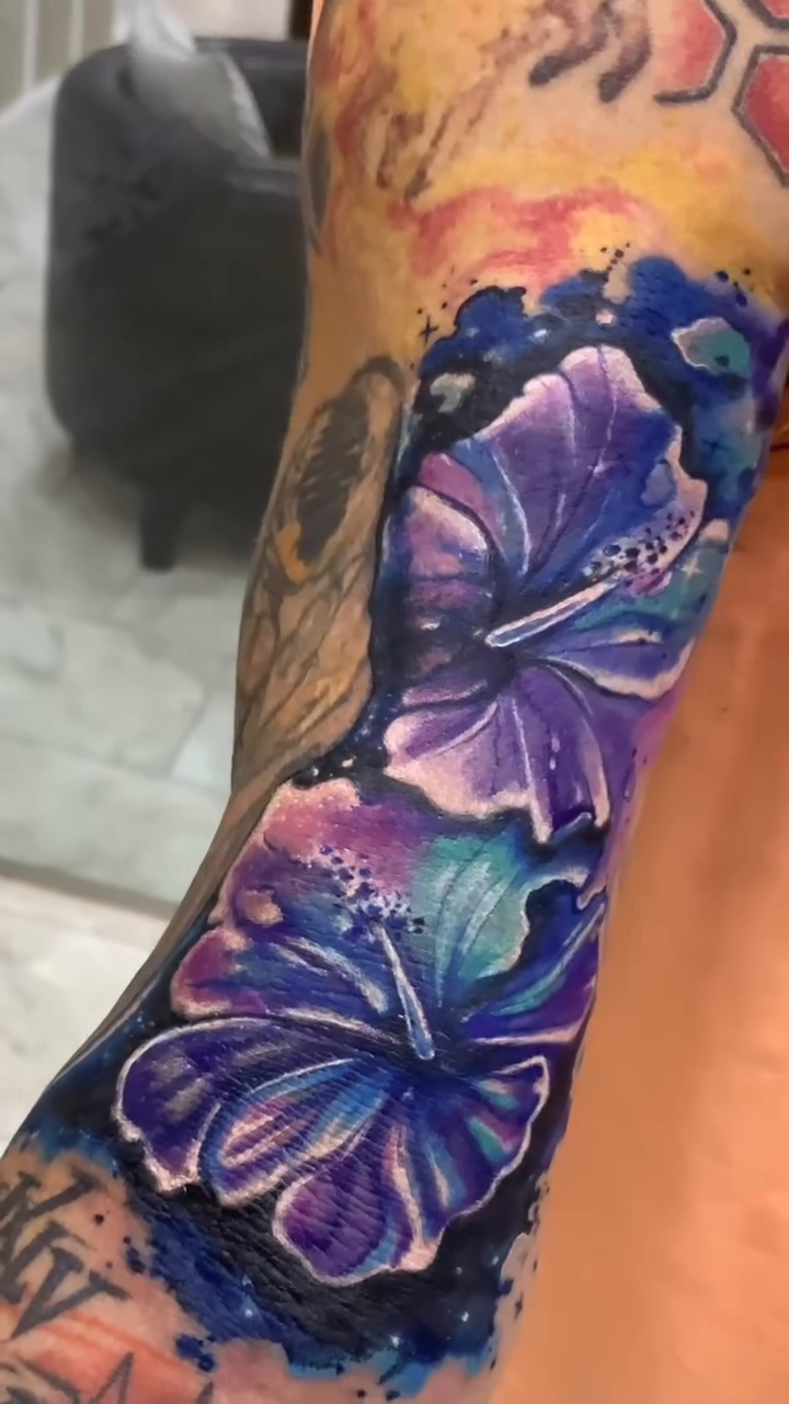 Resultado del cover-up de Laura Caselles: flores violetas sobre la zona central del brazo