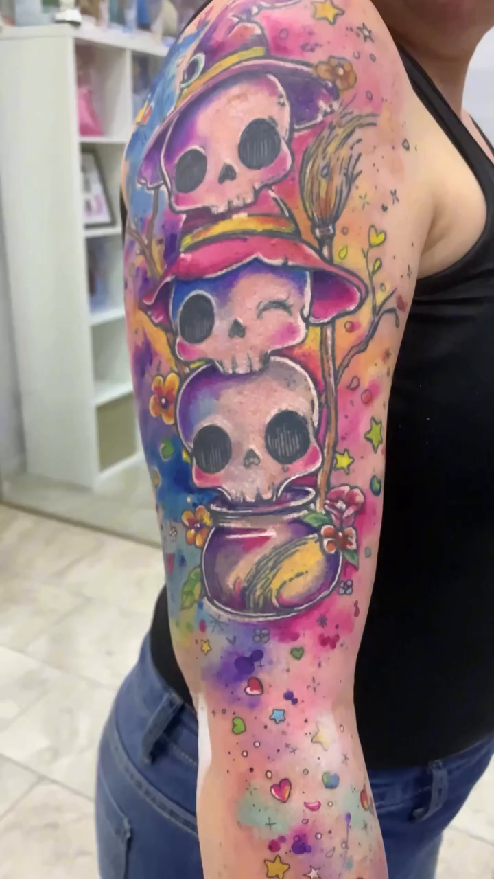Detalle de calaveritas, flores, corazones y manchas de color a lo largo del brazo