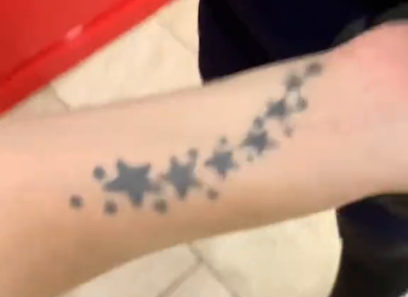 Hilera de estrellas oscuras de distintos tamaños en el antebrazo antes del cover-up de medusa