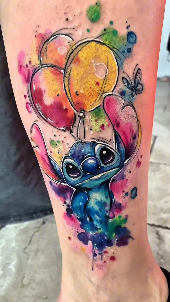 Laura Caselles' finished cover-up: blue Stitch, yellow and pink balloons and watercolour splashes on the leg