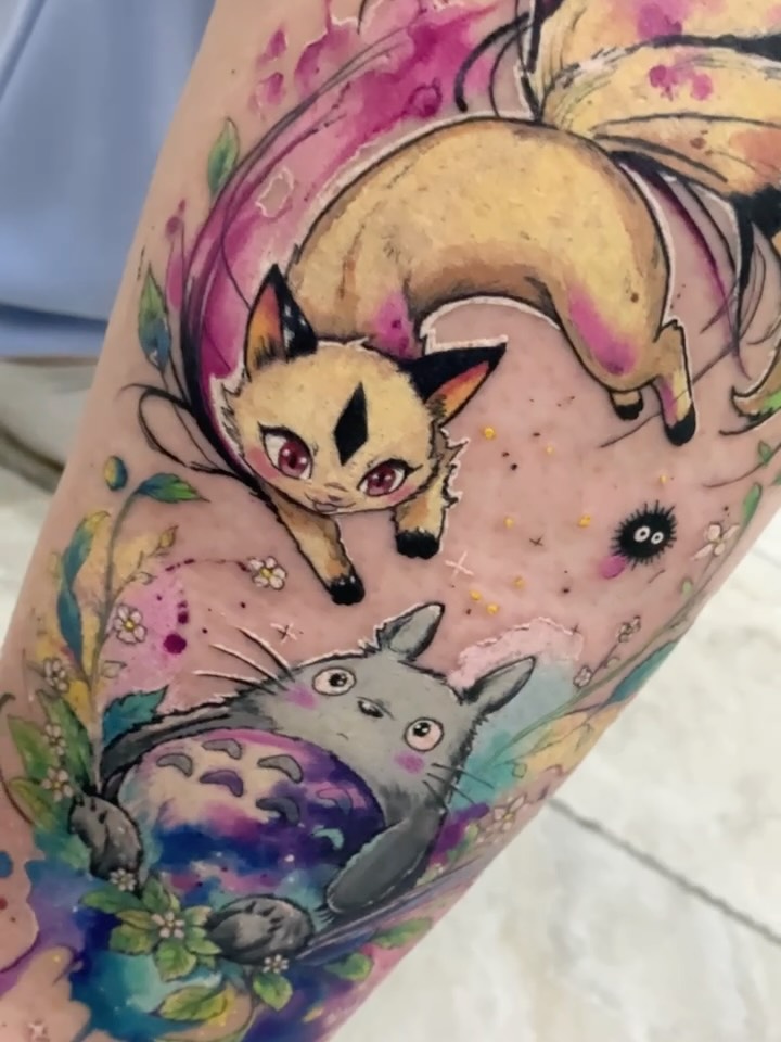 Primer plano del cover-up de Totoro, otro personaje, flores y acuarela en la pierna
