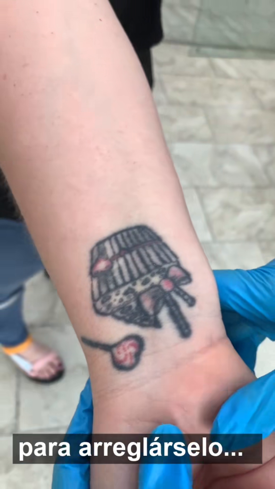 Tatuaje oscuro de un pastel junto a la muñeca, antes del arreglo de Laura Caselles