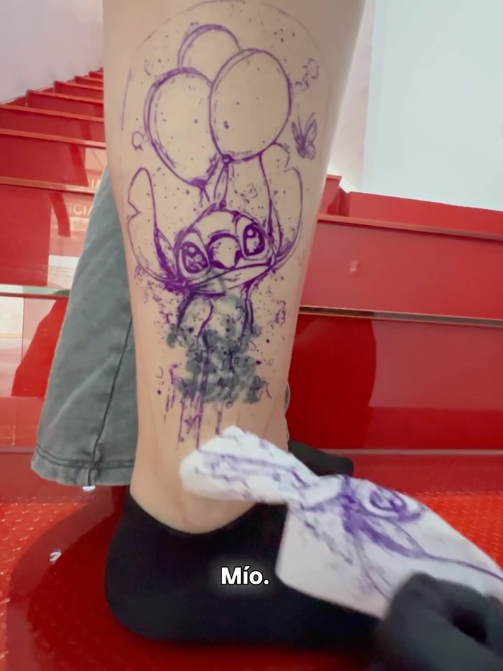 Stencil of Stitch and balloons over the previous tattoo, still visible on the lower leg