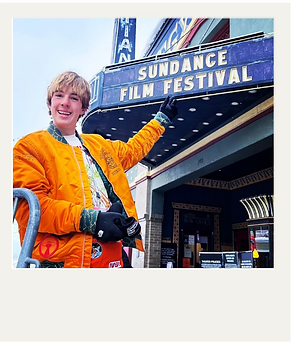 Collin Nelso in an visiting the sundance film festival in na orange jacket