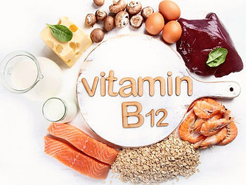 Foods rich in Vitamin B12, including salmon, eggs, shrimp, and cheese, surround a board reading "vitamin B12" on a white surface.