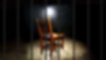 A wooden chair under a spotlight in a dim room, viewed through bars. The atmosphere is somber and isolated.