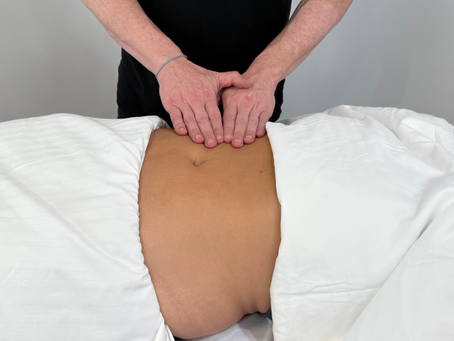 Therapist gently massaging a clients abdomen, lymphatic drainage massage