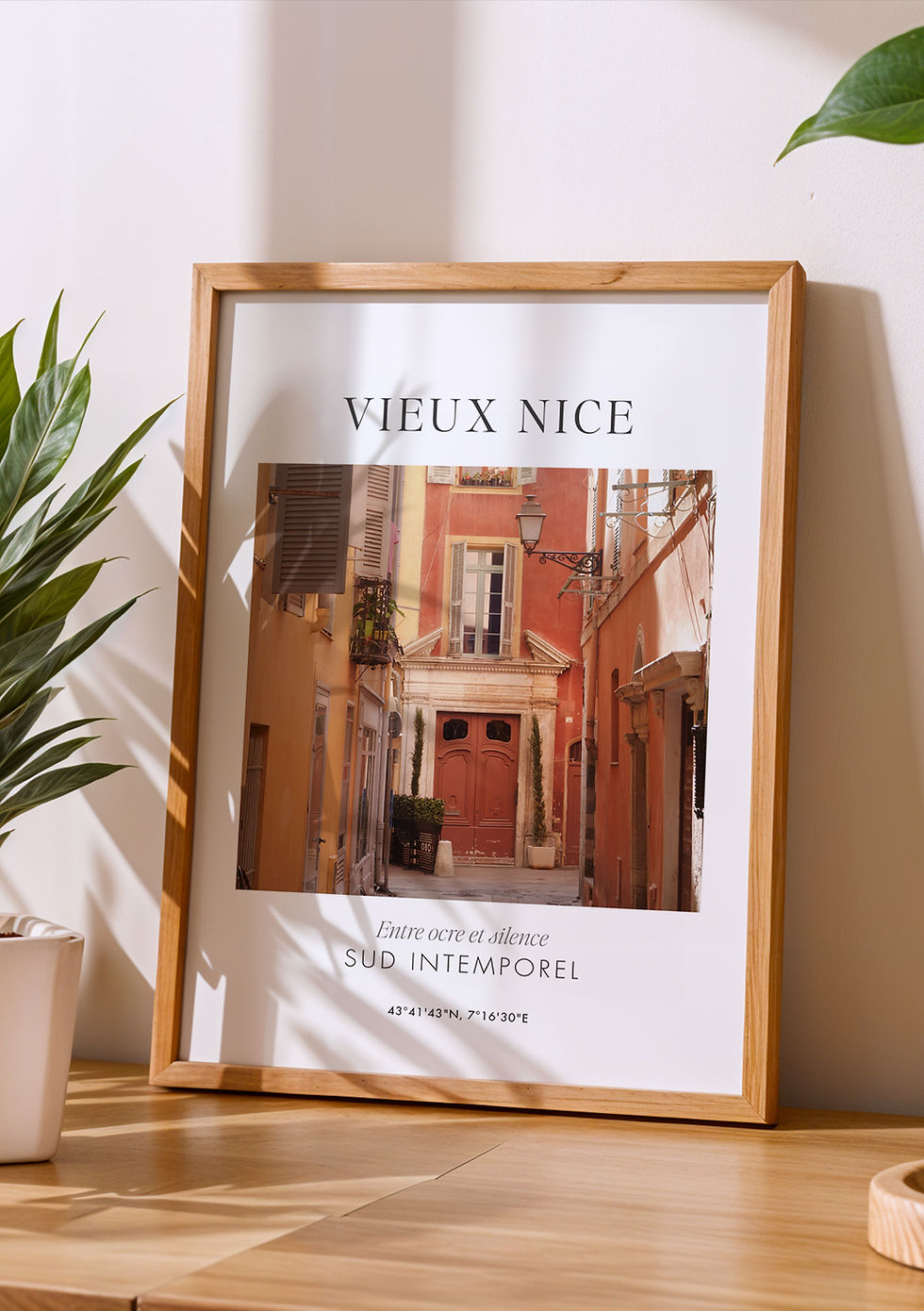 Affiche Vieux Nice encadrée en bois clair posée dans un intérieur lumineux au style naturel et épuré