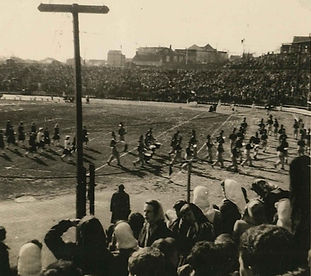 Historic Image of Hinchliffe Stadium with marching band and cheerleaders on the field and people in the grandstandsandstands