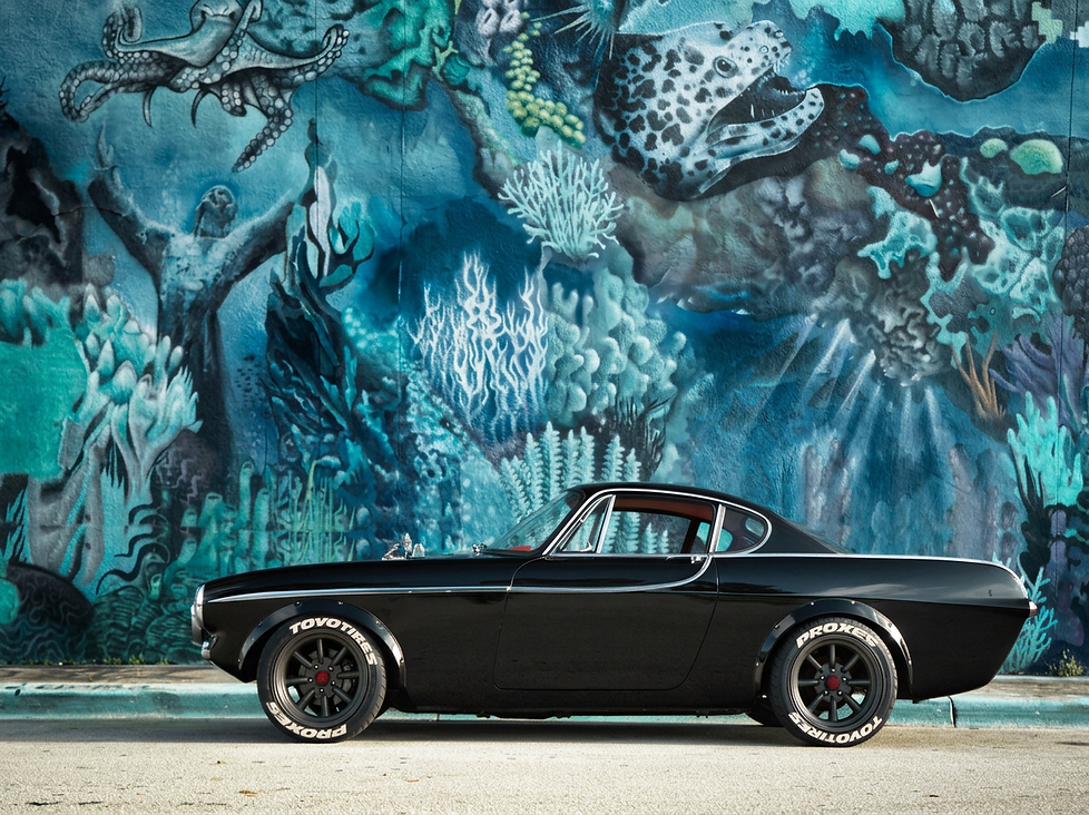 Black classic car in front of an underwater mural
