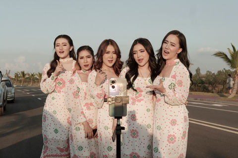 Influencers promote their clothing and skin care brand on Tik Tok shooting a video beside the That Luang artificial lake. . Vientiane Capital, Laos. November 2022.