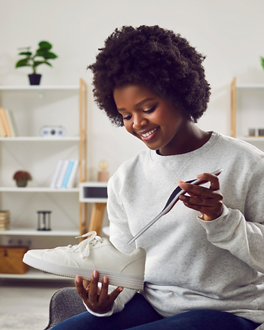 A black woman holding a shoe and her new inexpensive orthotics in Guelph Ontario