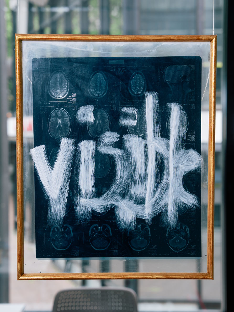 Photo of the artwork. The gold frame and the word "visible" in white are clearly visible. The MRI scan is only vaguely discernible.