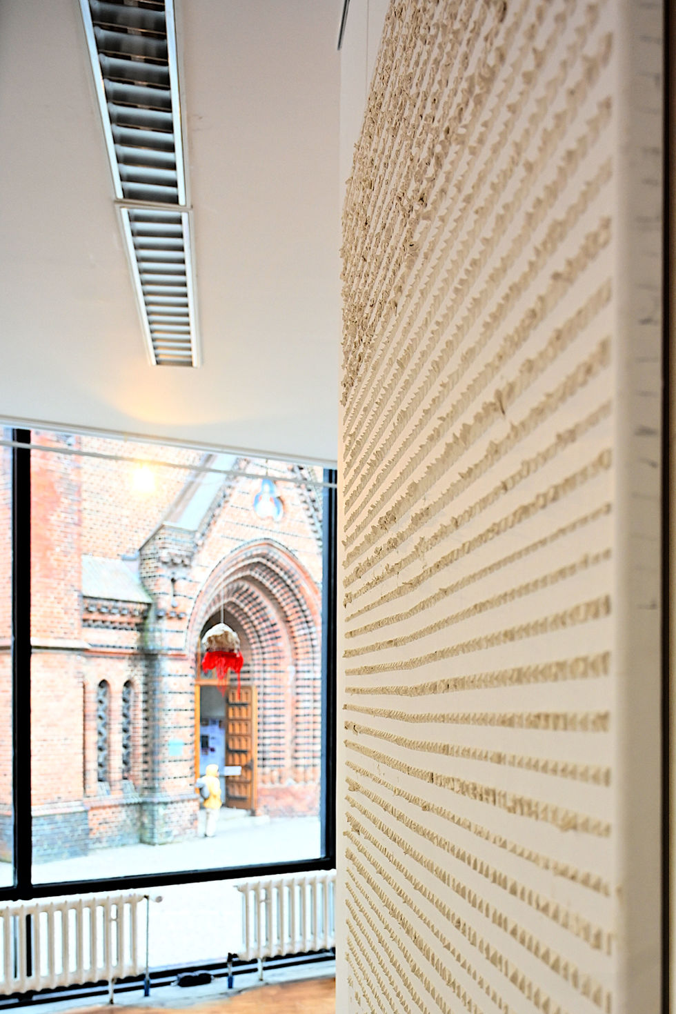 The artwork can be seen on the right edge of the picture. Behind it, you can see the window of the exhibition room with further artworks.