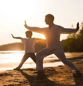 Family  dad and little son practice Tai Chi Chuan in the summer on the beach. solo outdoor