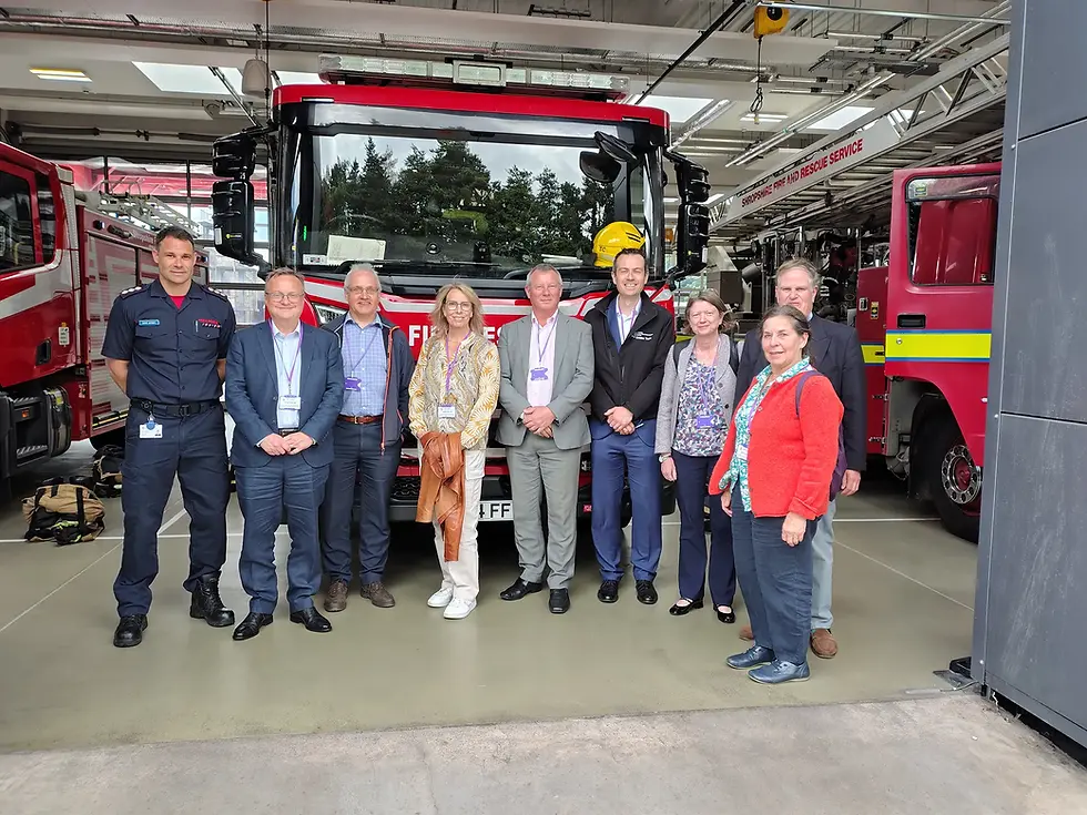 Group photograph of ACES Heart of England Branch members and host staff in front of a fire engine at Telford Central Fire Station.