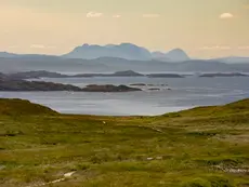 Panoramic view of Scottish coastal waters and distant mountain peaks near Handa and Alford.