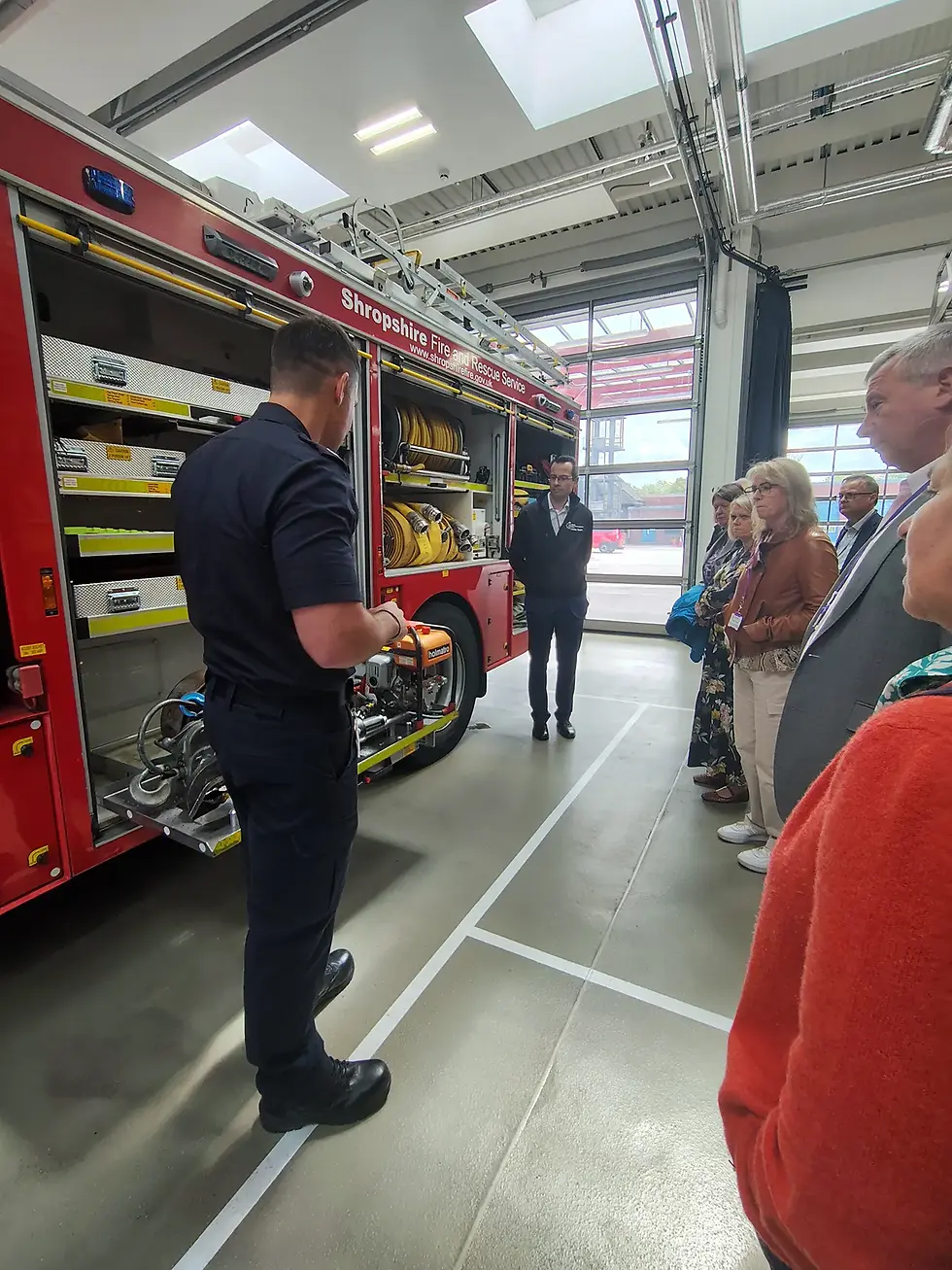 Station manager demonstrating fire engine equipment to ACES Heart of England Branch members at Telford Central Fire Station.