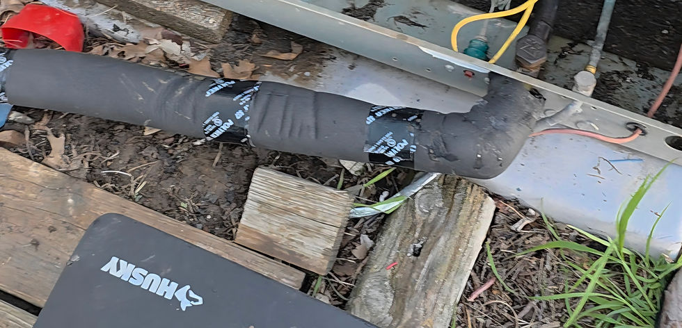 Wrapped black Husky hose repair in a muddy outdoor work area, with wood planks, wires, and pipes scattered around