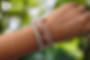 Person's arm wearing KNOW DEMENTIA bracelet before purple stained glass, with Dementia Society of America logo.