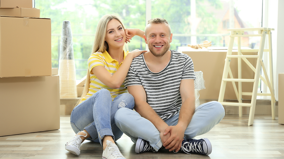 couple sitting with moving boxes | urbandogrealestate.com