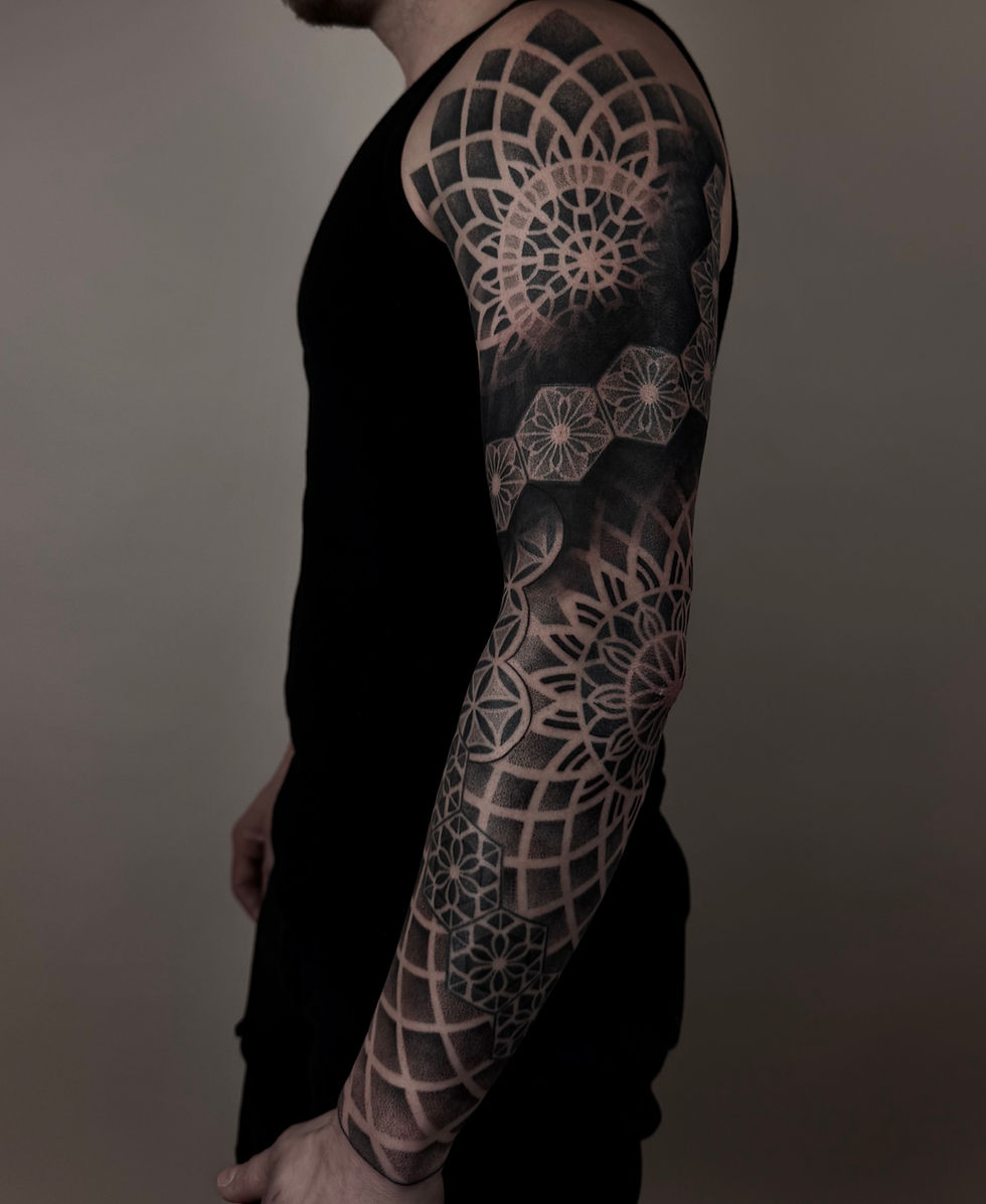 Mann mit geometrischem Ärmeltattoo
