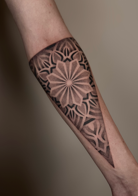 Detailreiches geometrisches Armtattoo mit Mandala-Elementen.