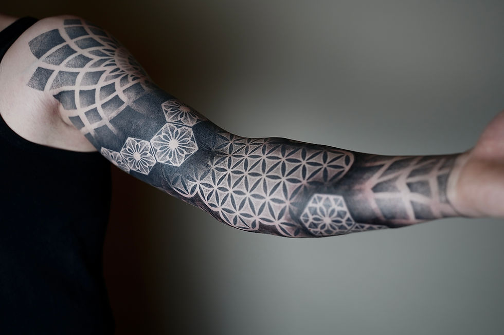 Schwarzweiß-Armtattoo mit geometrischen Mustern und Mandalas