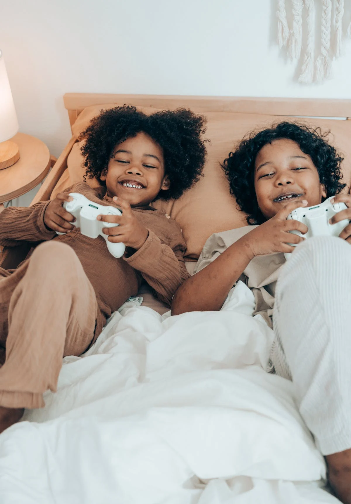 kids laying in bed and playing games