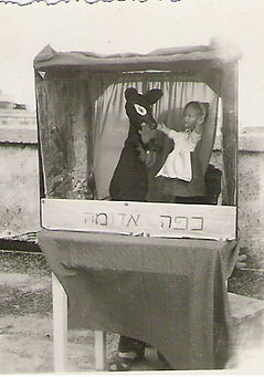 אמא מציגה את כיפה אדומה על הגג בגן רחביה 1957.jpg