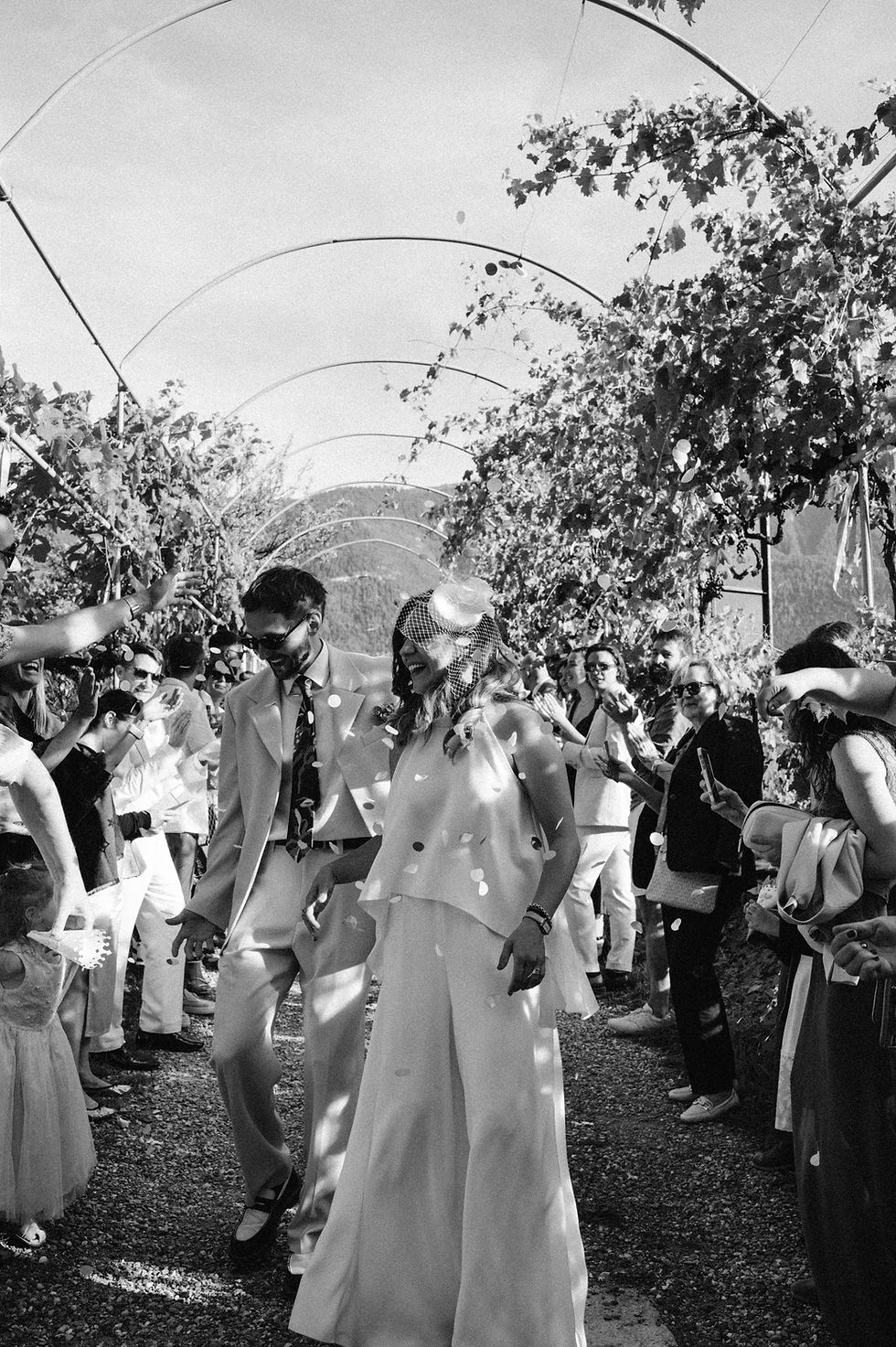 Newlyweds walking through a confetti exit after their outdoor wedding ceremony in Switzerland.